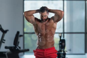 Young Italian Man Standing Strong In The Gym And Flexing Muscles - Muscular Athletic Bodybuilder Fitness Model Posing After Exercises