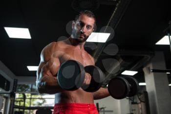 Bodybuilder Working Out Biceps In A Dark Gym - Dumbbell Concentration Curls