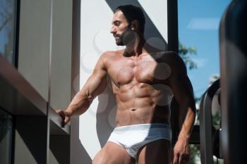 Portrait Of A Sexy Muscular Man In Underwear Looking Through Window