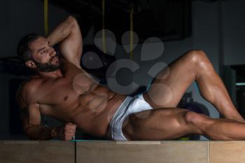 Portrait Of A Sexy Muscular Man In Underwear Resting On Box After Exercise