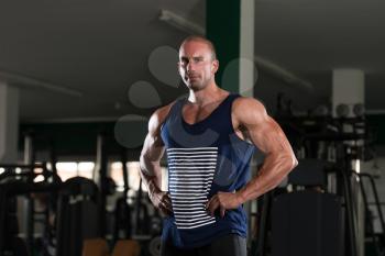 Young Bald Man Standing Strong In The Gym And Flexing Muscles - Muscular Athletic Bodybuilder Fitness Model Posing After Exercises