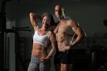 Portrait Of A Physically Fit Couple Showing Their Well Trained Body - Muscular Athletic Bodybuilder Fitness Model Posing After Exercises
