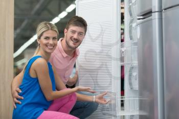 Beautiful Young Couple Shopping For Fridge In Produce Department Of A Grocery Store - Supermarket - Shallow Deep Of Field