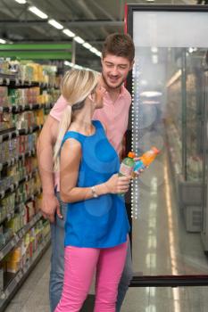 Beautiful Young Couple Shopping For Drink In Produce Department Of A Grocery Store - Supermarket - Shallow Deep Of Field