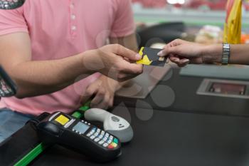 Close Up Woman Paying Groceries at Supermarket Checkout With Card