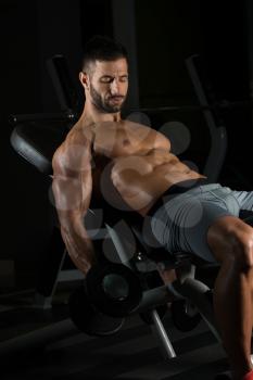 Healthy Man Working Out Biceps In A Dark Gym - Dumbbell Concentration Curls