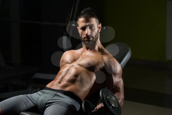 Handsome Man Working Out Biceps In A Dark Gym - Dumbbell Concentration Curls