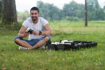 Closeup of Young Engineer Man Checking the Battery of Uav Drone With Hand Tool in Park