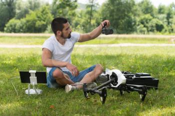 Closeup of Young Engineer Man Checking the Camera from a Drone With Hand in Park