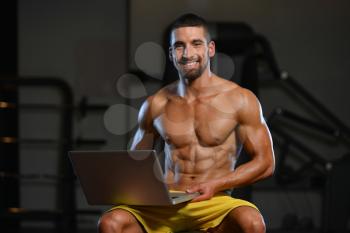 Portrait Of A Young Physically Fit Man Using Laptop - Muscular Athletic Bodybuilder Fitness Model Use Computer