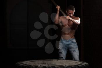 Athletic Man In Pants Hits Tire - Workout At Gym With Hammer And Tractor Tire