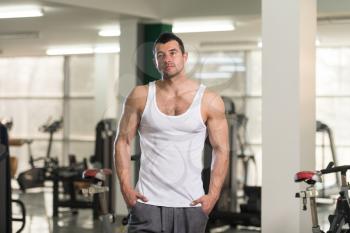 Portrait Of A Young Physically Fit Man In White Undershirt Showing His Well Trained Body - Muscular Athletic Bodybuilder Fitness Model Posing After Exercises