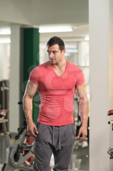Handsome Young Man Standing Strong in Pink T-shirt and Flexing Muscles - Muscular Athletic Bodybuilder Fitness Model Posing After Exercises
