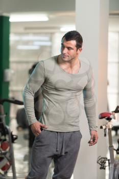 Healthy Young Man in Green T-shirt Long Sleevs Standing Strong and Flexing Muscles - Muscular Athletic Bodybuilder Fitness Model Posing After Exercises