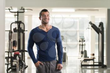 Handsome Young Man Standing Strong in Blue T-shirt and Flexing Muscles - Muscular Athletic Bodybuilder Fitness Model Posing After Exercises