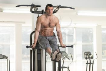 Hairy Muscular Fitness Bodybuilder Doing Heavy Weight Exercise For Abdominal on Parallel Bars In The Gym