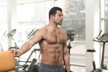 Strong Hairy Man In The Gym And Exercising Shoulders With Dumbbells - Muscular Athletic Bodybuilder Fitness Model Exercise Shoulder