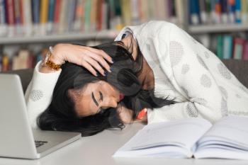 Sleeping Woman Student Sitting And Leaning On Pile Of Books In College - Shallow Depth Of Field