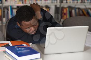 Sleeping African Student Sitting And Leaning On Pile Of Books In College - Shallow Depth Of Field