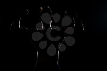 Silhouette Muscular Man Posing On Isolated On Black Background