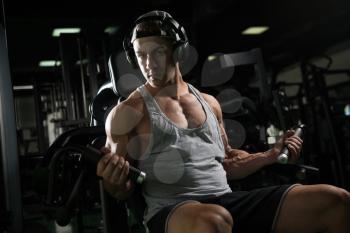 Young Bodybuilder Doing Heavy Weight Exercise For Biceps On Machine