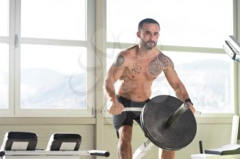 Handsome Athlete Doing Heavy Weight Exercise For Back On Machine