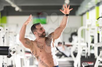 Portrait Of A Young Physically Fit Tattoo Man Showing His Well Trained Body - Muscular Athletic Bodybuilder Fitness Model Posing After Exercises
