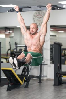 Young Man Performing Hanging Leg Raises Exercise - One Of The Most Effective Ab Exercises