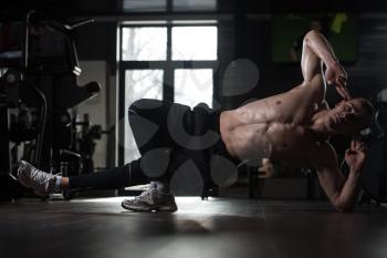 Young Man Athlete Abbs Exercises On Floor As Part Of Bodybuilding Training