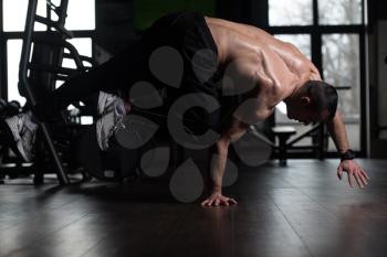 Young Man Athlete Doing Extreme Handstand On One Hand As Part Of Bodybuilding Training