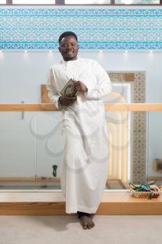 Portrait Of A African Muslim Man Making Traditional Prayer To God While Wearing A Traditional Cap Dishdasha
