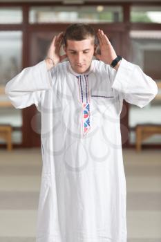 Portrait Of A Caucasian Muslim Man Making Traditional Prayer To God While Wearing A Traditional Cap Dishdasha