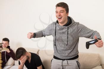 Three Friends Are Focused on Playing Video Games At Home