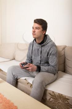 Young Man Having Happy Time Playing Video Games At Home