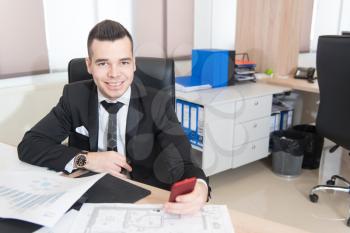 Young Handsome Businessman Working At Desk In The Modern Office Talking On Phone