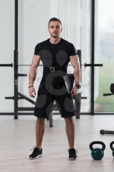 Personal Trainer In Sports Outfit Takes Notes On Clipboard In A Fitness Center Gym Standing Strong