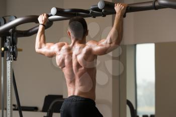 Man Athlete Doing Pull Ups - Chin-Ups In The Gym