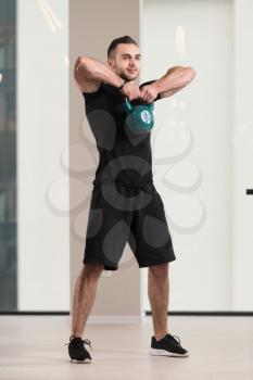 Man Working Out With Kettle Bell In A Dark Gym - Bodybuilder Doing Heavy Weight Exercise With Kettle-bell