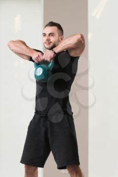 Man Exercising With Kettle Bell And Flexing Muscles - Muscular Athletic Bodybuilder Fitness Model Exercises