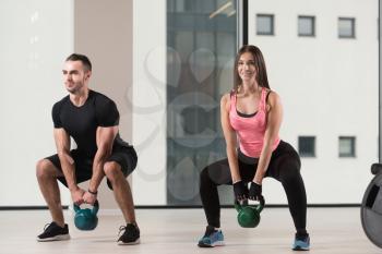 Young Woman And Man Working With Kettle Bell In A Gym - Kettle-bell Exercise