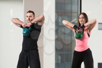 Young Woman And Man Working With Kettle Bell In A Gym - Kettle-bell Exercise