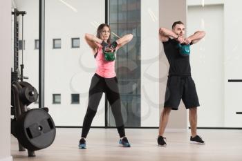 Fitness Woman And Man Working With Kettle Bell In A Gym - Kettle-bell Exercise