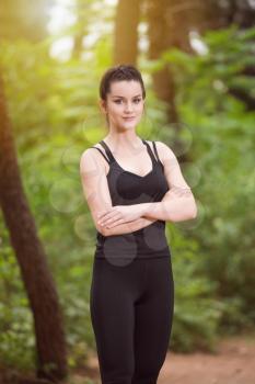 Portrait of a Young Woman Running In Wooded Forest Area - Training And Exercising For Trail Run Marathon Endurance - Fitness Healthy Lifestyle Concept