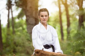 Woman Dressed In Traditional Kimono Resting After Practicing Her Karate Moves In Wooded Forest Area