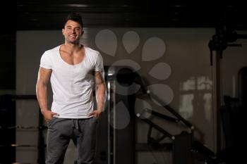 Handsome Young Man Standing Strong in White T-shirt and Flexing Muscles - Muscular Athletic Bodybuilder Fitness Model Posing After Exercises