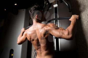 Athlete Doing Heavy Weight Exercise For Back On Machine