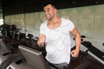 Healthy Man Running On Treadmill In A Modern Fitness Center