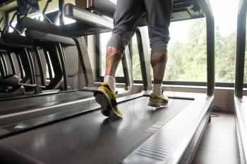 Close-up Of Male Legs Running On Treadmill - Blurred Motion
