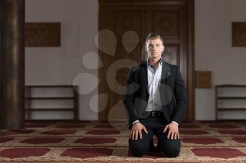 Attractive Blond Man Making Traditional Prayer to God Allah in the Mosque