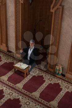 Businessman Muslim Is Reading The Koran Making Traditional Prayer to God Allah in the Mosque